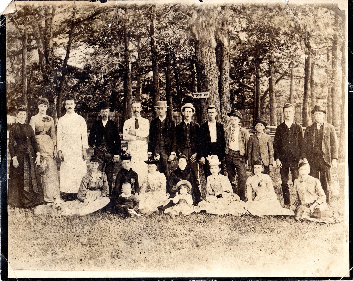 Group of unidentified people gathered under trees beneath a 'Ryerson Park' sign, around 1890.